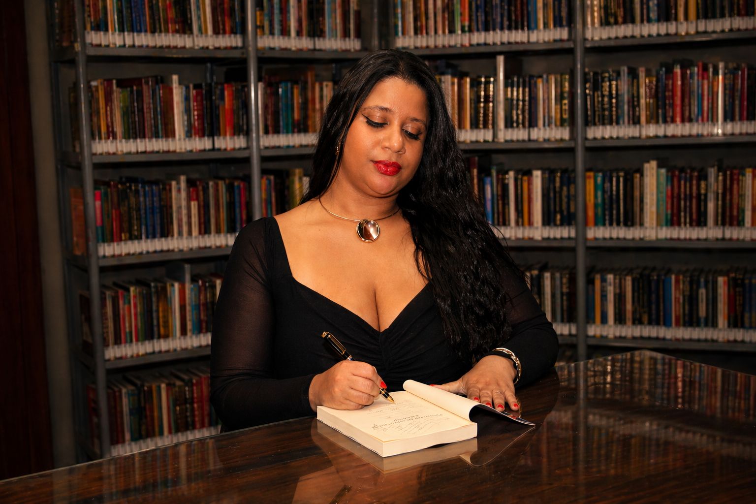 Miria Jesus assinando exemplar do livro Mulheres da Advocacia Criminal